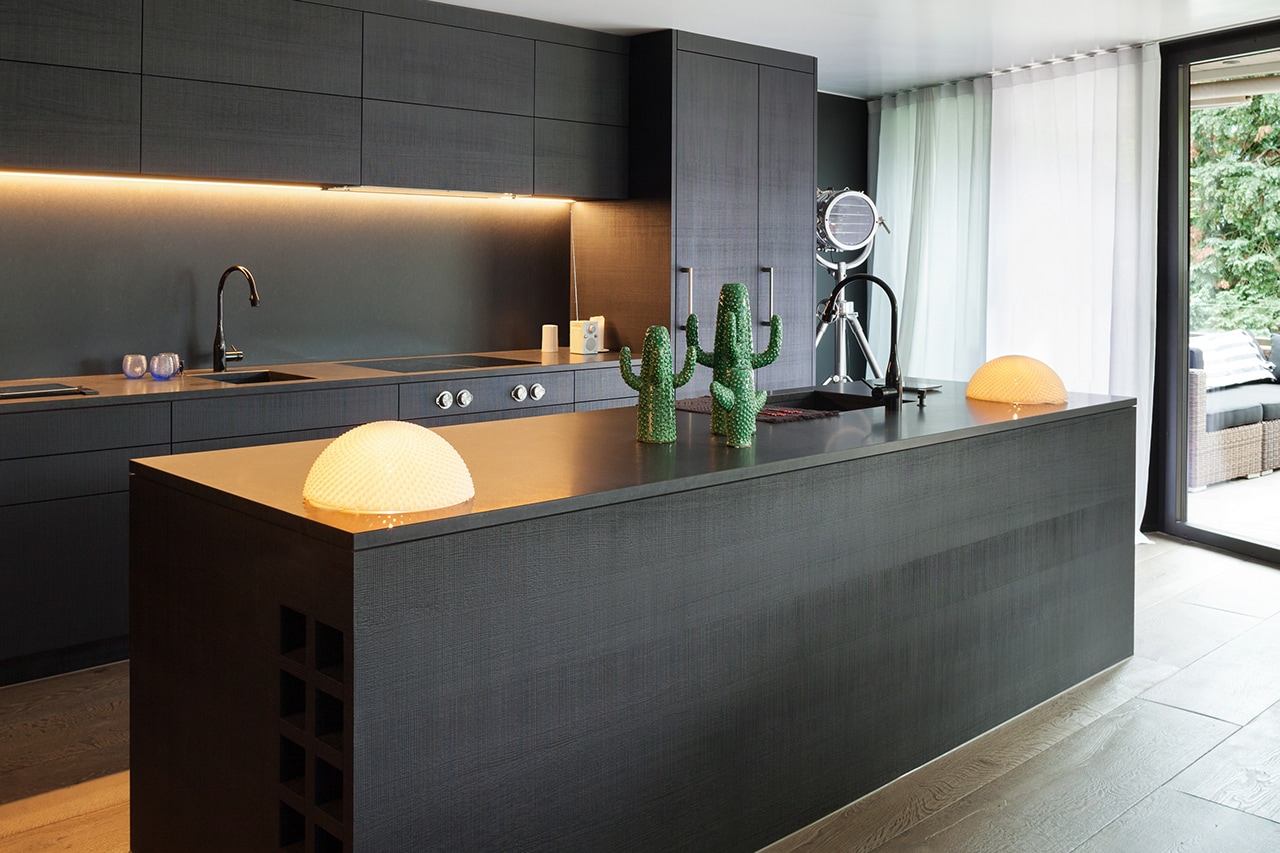 Modern kitchen with black furniture and wooden floor