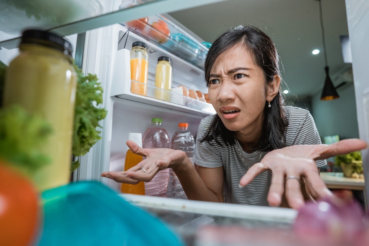 Verwarde vrouw met overvolle frigo