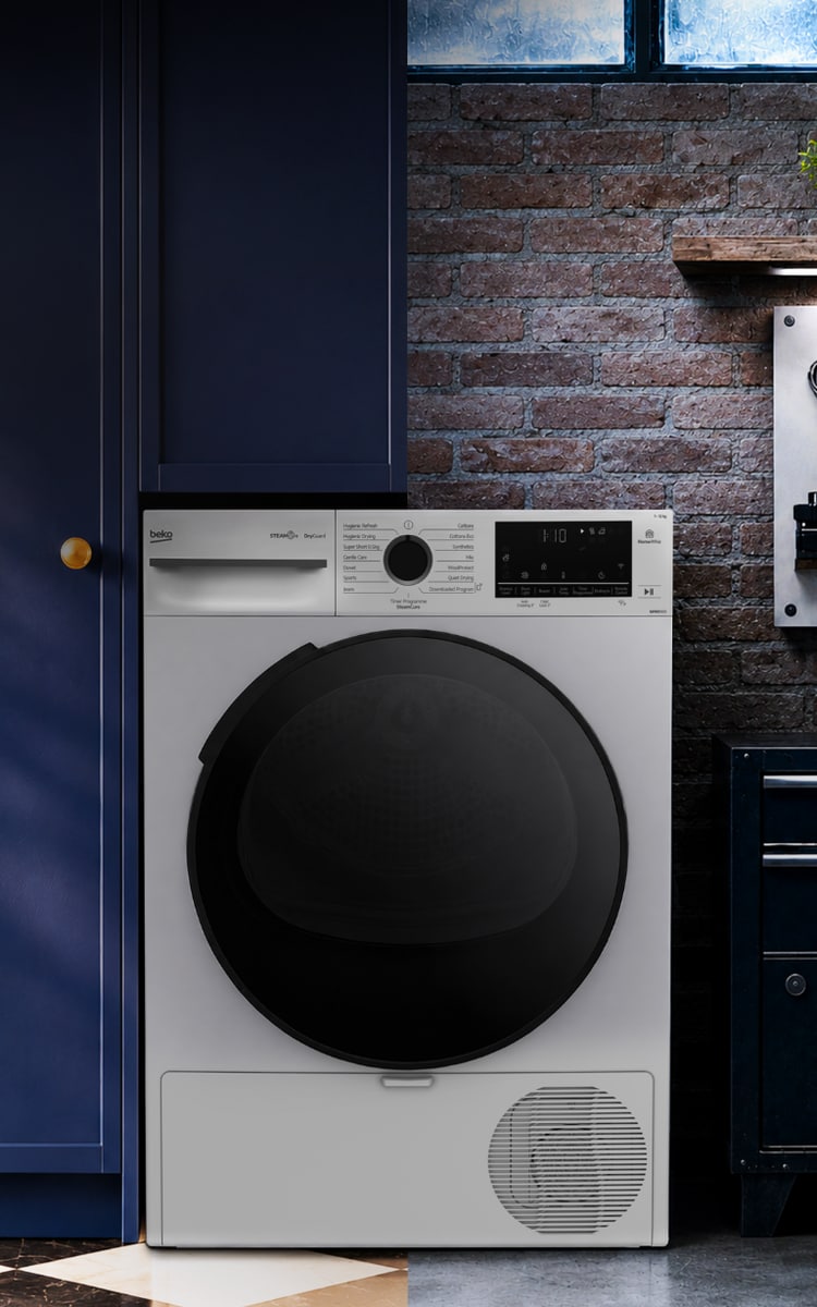 Beko DryGuard szárítógép modern, sötétkék konyhai enteriőrben, téglafal előtt.