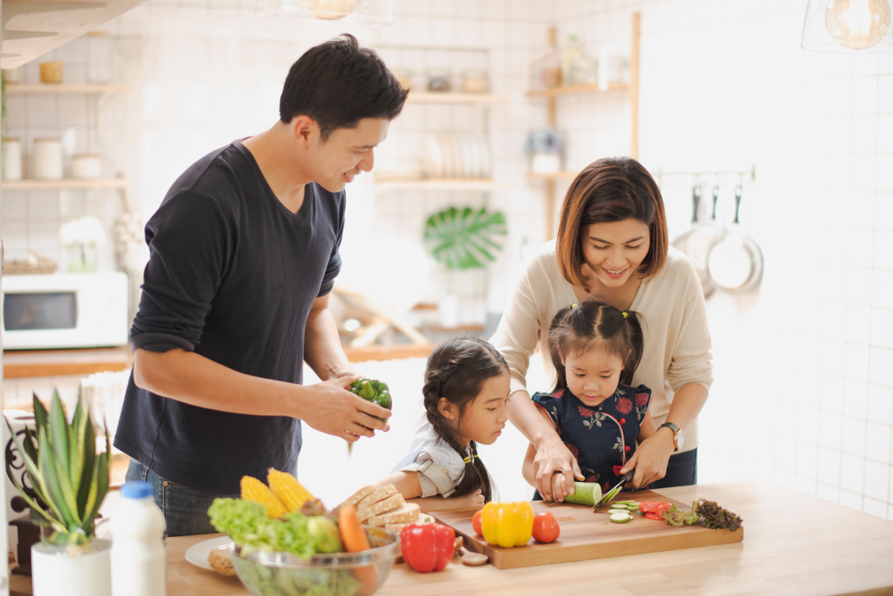 family teaching their kids to prepare healthy foods